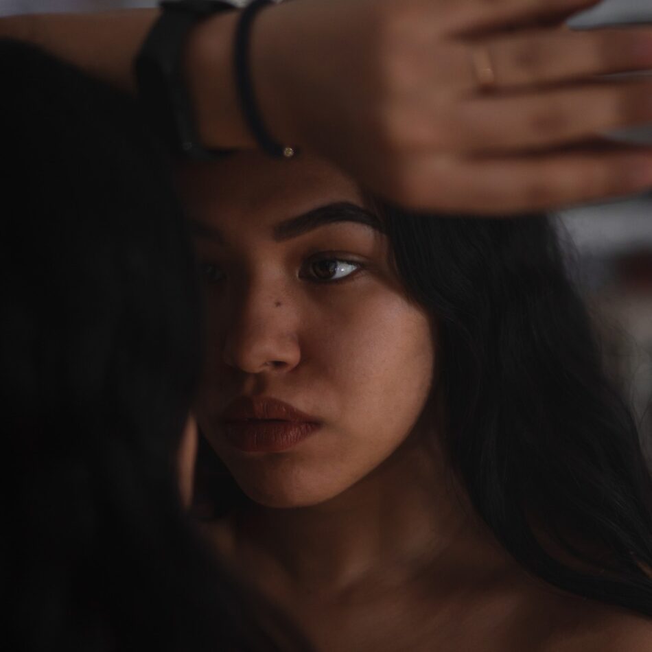 Foto do rosto de uma mulher, com olhar distante. Para ilustrar o texto A importância de um diagnóstico acessível.